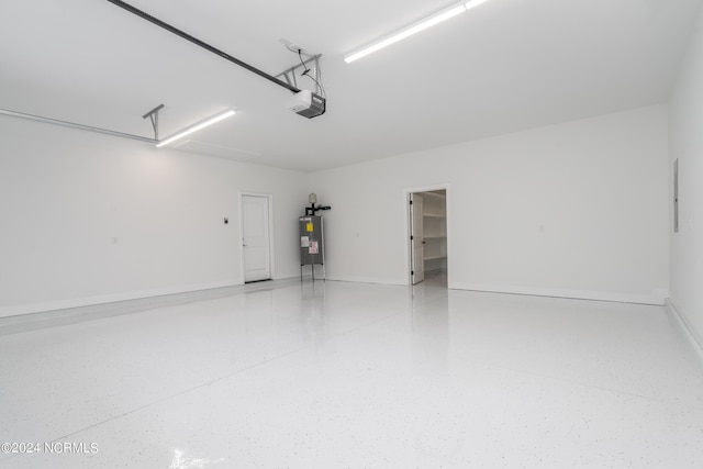 garage with baseboards, electric water heater, and a garage door opener