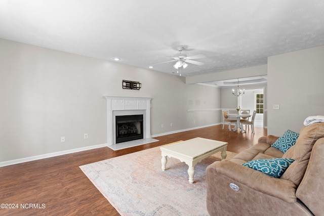 living room featuring dark hardwood / wood-style floors and ceiling fan with notable chandelier