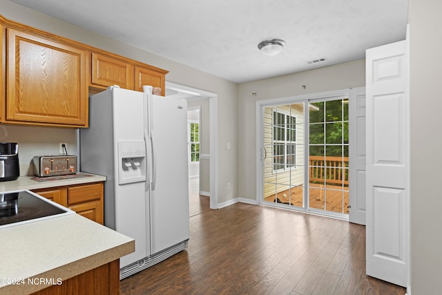 kitchen featuring dark hardwood / wood-style flooring and white refrigerator with ice dispenser