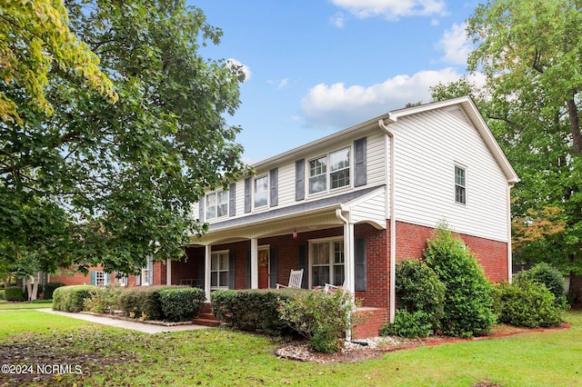 view of front of property with covered porch and a front yard