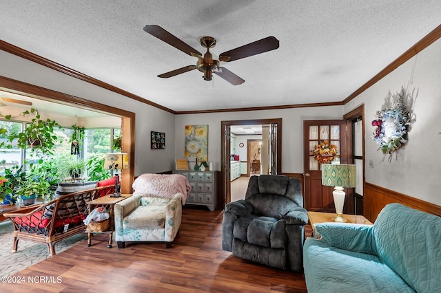 living room featuring ceiling fan, crown molding, dark wood-type flooring, and a textured ceiling