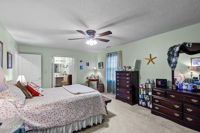 bedroom with connected bathroom, ceiling fan, light colored carpet, and a textured ceiling