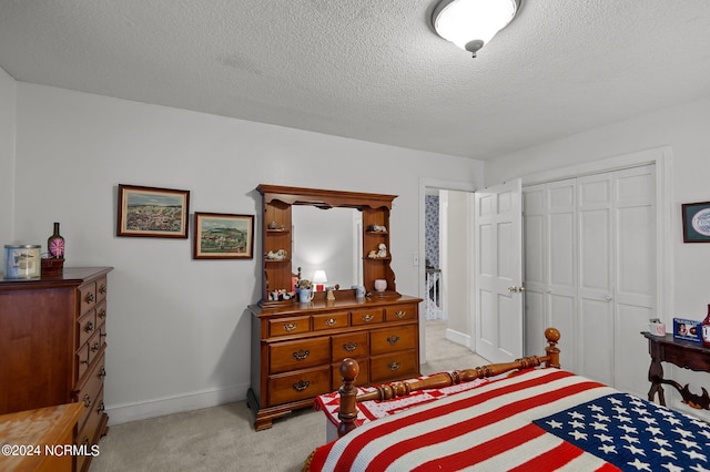 carpeted bedroom featuring a textured ceiling and a closet