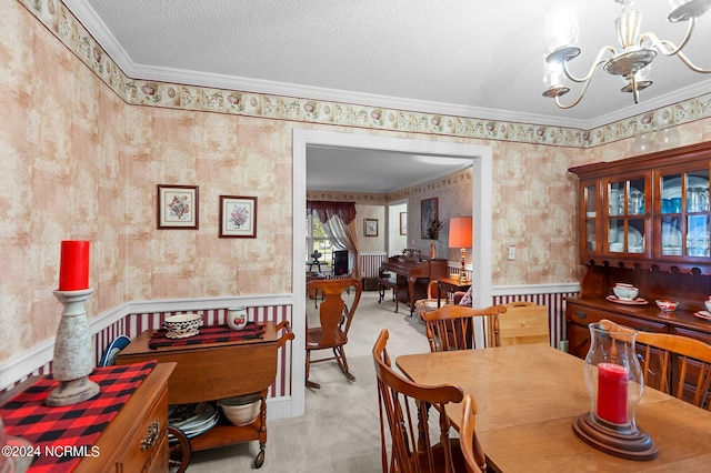 dining room featuring light carpet, a notable chandelier, crown molding, and a textured ceiling