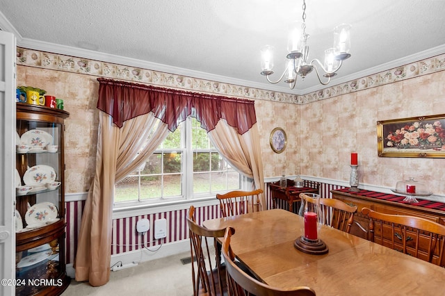 dining room with a textured ceiling, crown molding, carpet flooring, and a chandelier