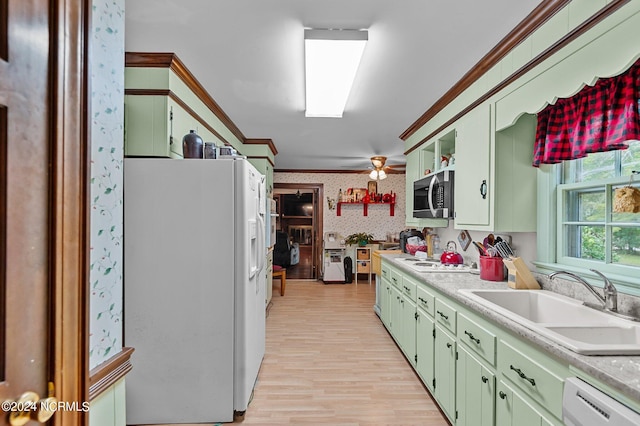 kitchen featuring ornamental molding, sink, white appliances, green cabinetry, and light wood-type flooring