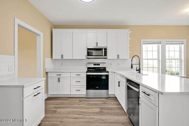 5104 Boss Ct SE, Southport, NC 28461 - kitchen featuring appliances with stainless steel finishes, a sink, a peninsula, and white cabinets