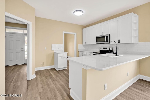 5104 Boss Ct SE, Southport, NC 28461 - kitchen with stainless steel microwave, open shelves, light wood finished floors, and a sink