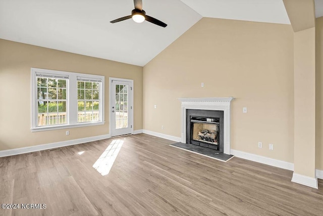 5104 Boss Ct SE, Southport, NC 28461 - unfurnished living room featuring a ceiling fan, wood finished floors, high vaulted ceiling, a fireplace, and baseboards