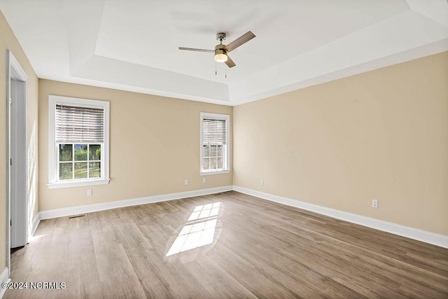 5104 Boss Ct SE, Southport, NC 28461 - spare room with a tray ceiling, a ceiling fan, wood finished floors, and baseboards