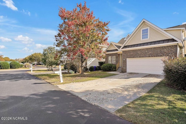 5104 Boss Ct SE, Southport, NC 28461 - view of front facade featuring a standing seam roof, driveway, brick siding, a front lawn, and metal roof