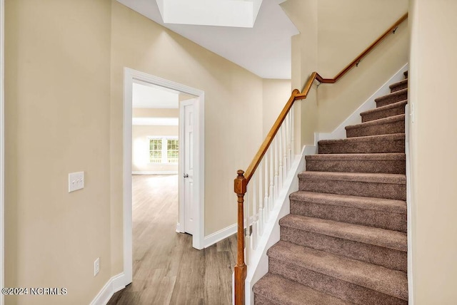 5104 Boss Ct SE, Southport, NC 28461 - stairs with wood finished floors, baseboards, and a skylight