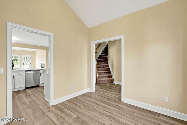 5104 Boss Ct SE, Southport, NC 28461 - unfurnished room featuring light wood-style flooring, vaulted ceiling, baseboards, stairs, and a sink