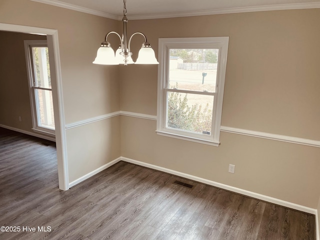 spare room featuring hardwood / wood-style flooring, crown molding, and a chandelier