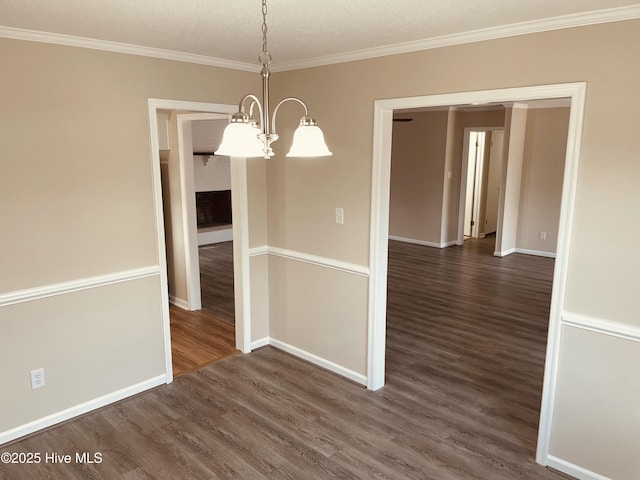 unfurnished dining area featuring ornamental molding, dark hardwood / wood-style floors, and a chandelier