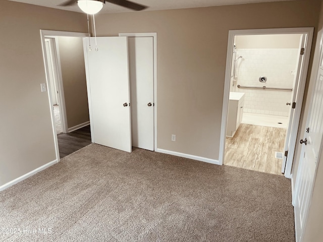 unfurnished bedroom with ensuite bath, carpet flooring, ceiling fan, and a closet