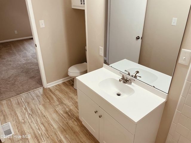 bathroom with vanity, hardwood / wood-style floors, and toilet