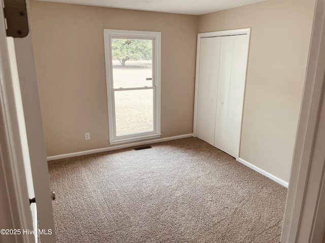 unfurnished bedroom with carpet flooring and a closet