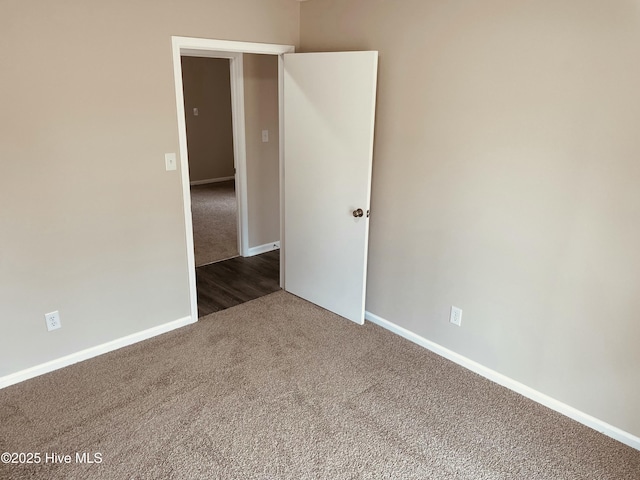 spare room featuring dark colored carpet