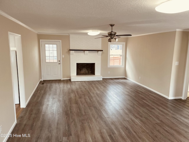 unfurnished living room with ornamental molding, dark hardwood / wood-style floors, a textured ceiling, and a wealth of natural light