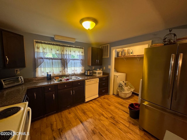 kitchen with light wood-type flooring, dishwasher, sink, stainless steel refrigerator, and dark brown cabinetry