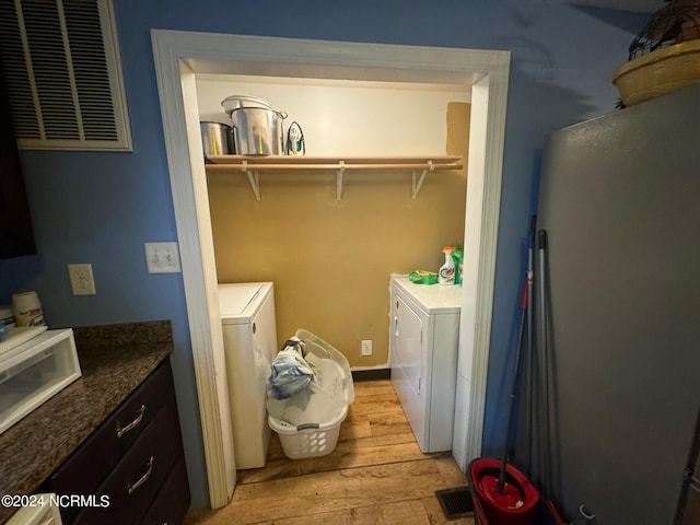 laundry area with light wood-type flooring and independent washer and dryer