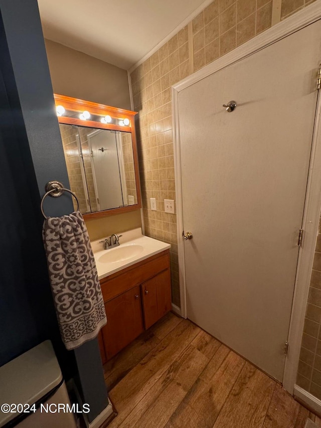 bathroom with vanity, hardwood / wood-style flooring, tile walls, and toilet