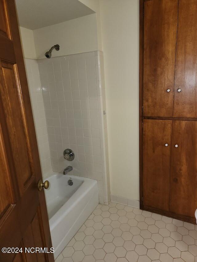 bathroom featuring tile patterned floors and tiled shower / bath combo