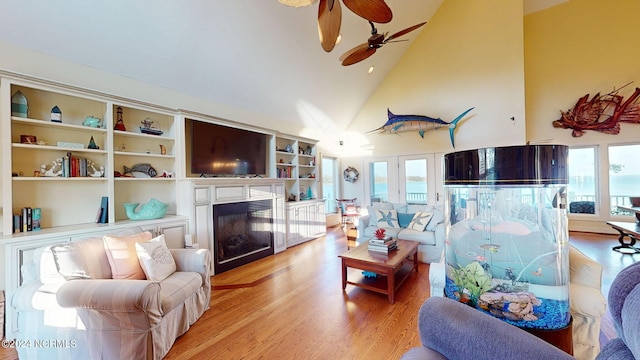 living room featuring high vaulted ceiling, hardwood / wood-style floors, ceiling fan, and french doors