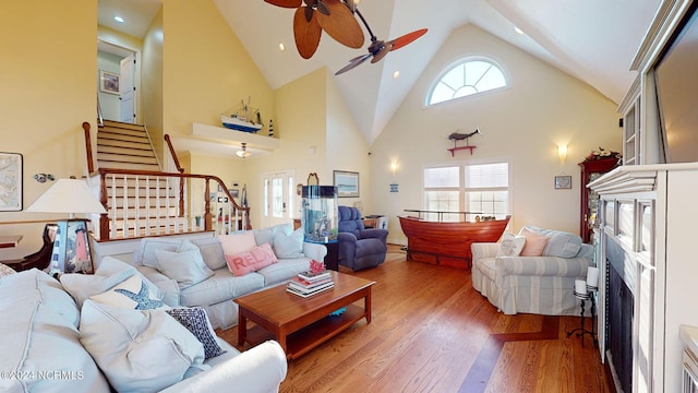 living room featuring a wealth of natural light, high vaulted ceiling, ceiling fan, and wood-type flooring