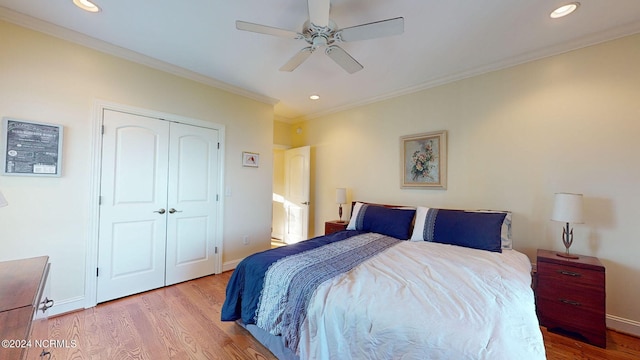 bedroom with light wood-type flooring, a closet, ceiling fan, and crown molding