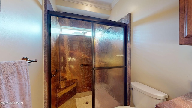 bathroom featuring toilet, a stall shower, and ornamental molding