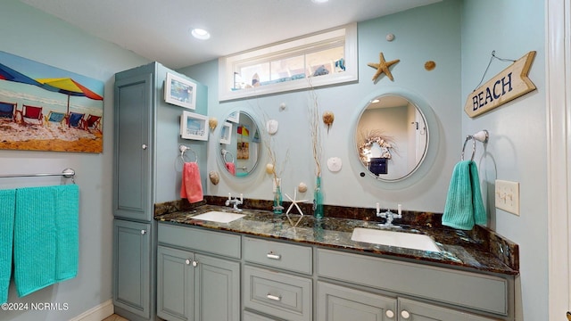 full bath with double vanity, a sink, and recessed lighting