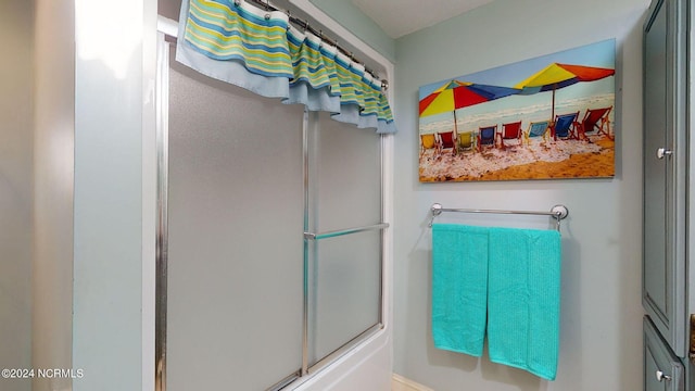 bathroom with bath / shower combo with glass door