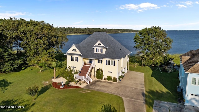 view of front of house with a garage, a water view, and a front lawn