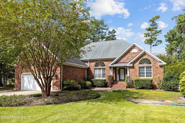 view of front of property featuring a front yard and a garage