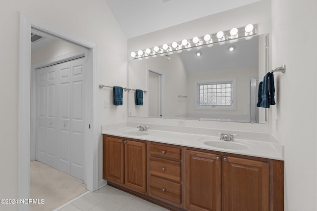 bathroom with vanity, vaulted ceiling, and tile patterned floors