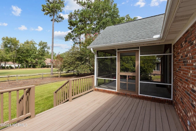 wooden terrace featuring a yard and a sunroom