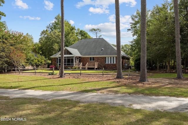 view of front of property with a deck and a front lawn