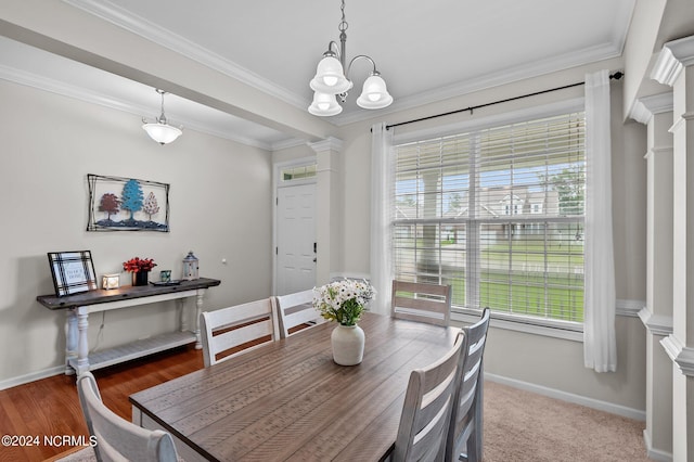 dining area with decorative columns, crown molding, plenty of natural light, and hardwood / wood-style flooring