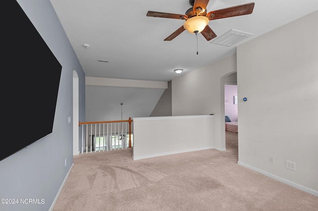 spare room with ceiling fan, lofted ceiling, and light carpet