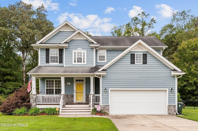 craftsman inspired home featuring a front yard, a porch, and a garage