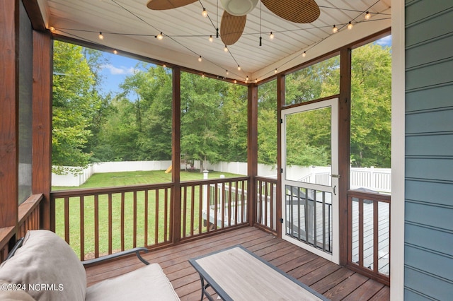 unfurnished sunroom featuring ceiling fan