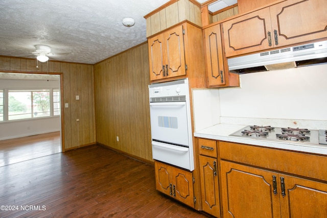 kitchen featuring white gas stovetop, wooden walls, a textured ceiling, ceiling fan, and dark hardwood / wood-style floors