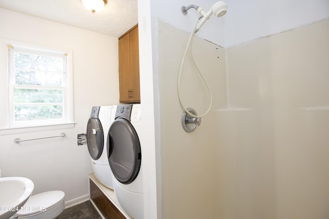 laundry area featuring a textured ceiling, a wealth of natural light, and washing machine and dryer