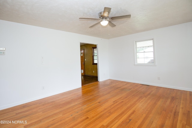 unfurnished room with light wood-type flooring, ceiling fan, and a textured ceiling