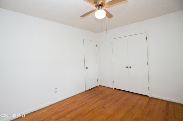 unfurnished bedroom featuring hardwood / wood-style floors, ceiling fan, a closet, and a textured ceiling