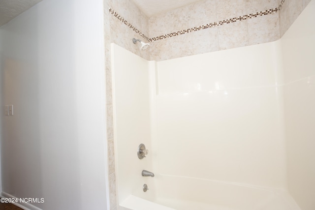 bathroom featuring a textured ceiling and shower / bathing tub combination