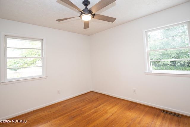 empty room with light wood-type flooring, ceiling fan, and plenty of natural light