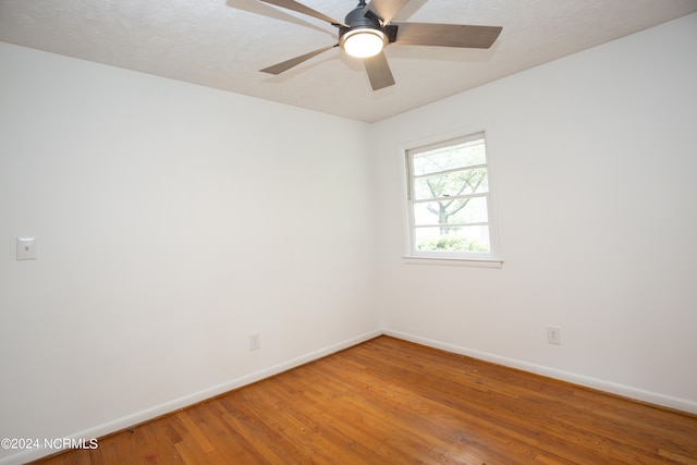 spare room with a textured ceiling, wood-type flooring, and ceiling fan